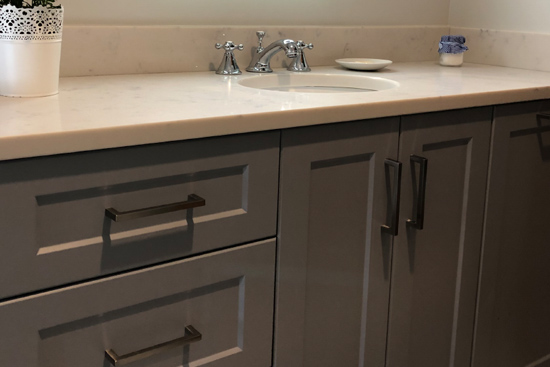 New grey vanity bathroom with custom CNC doors and white countertop with under mount sink