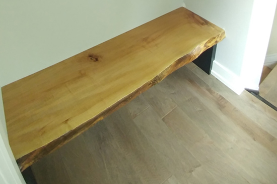 Mud room with live edge bench seat and coat hooks with storage uppers 