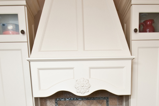 Custom CNC range hood, custom base corbels around glass cook top and solid surface counter top