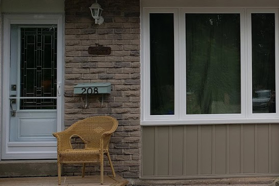 Replacement front door and picture window flanked with casement windows.